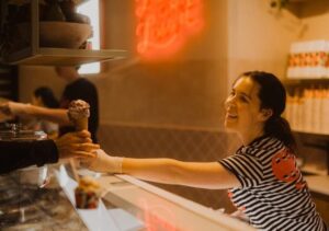 Island Gelato - Ice cream handed to customer by smiling atendant